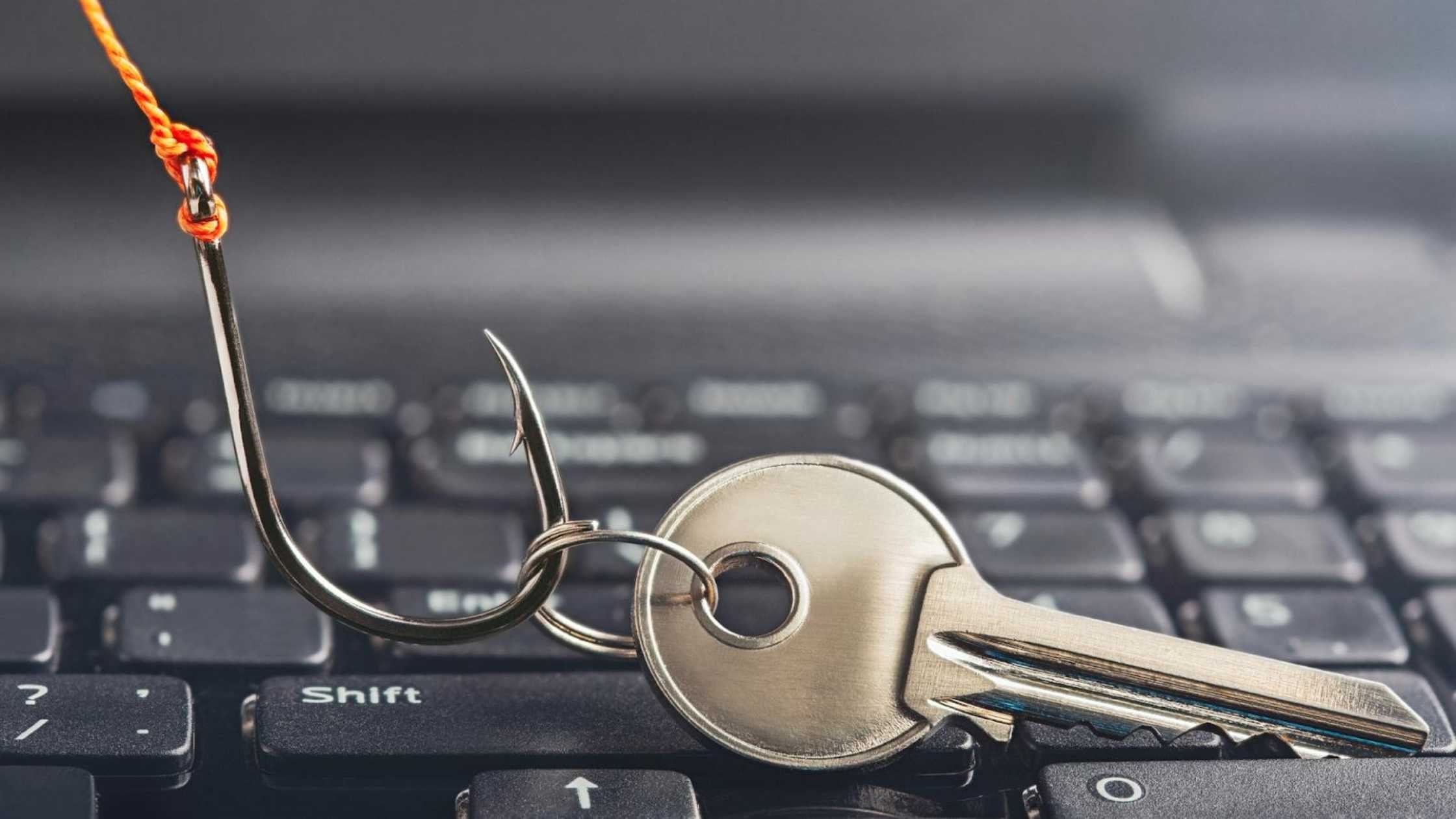 Phishing concept; Key on a fishing hook over a computer keyboard