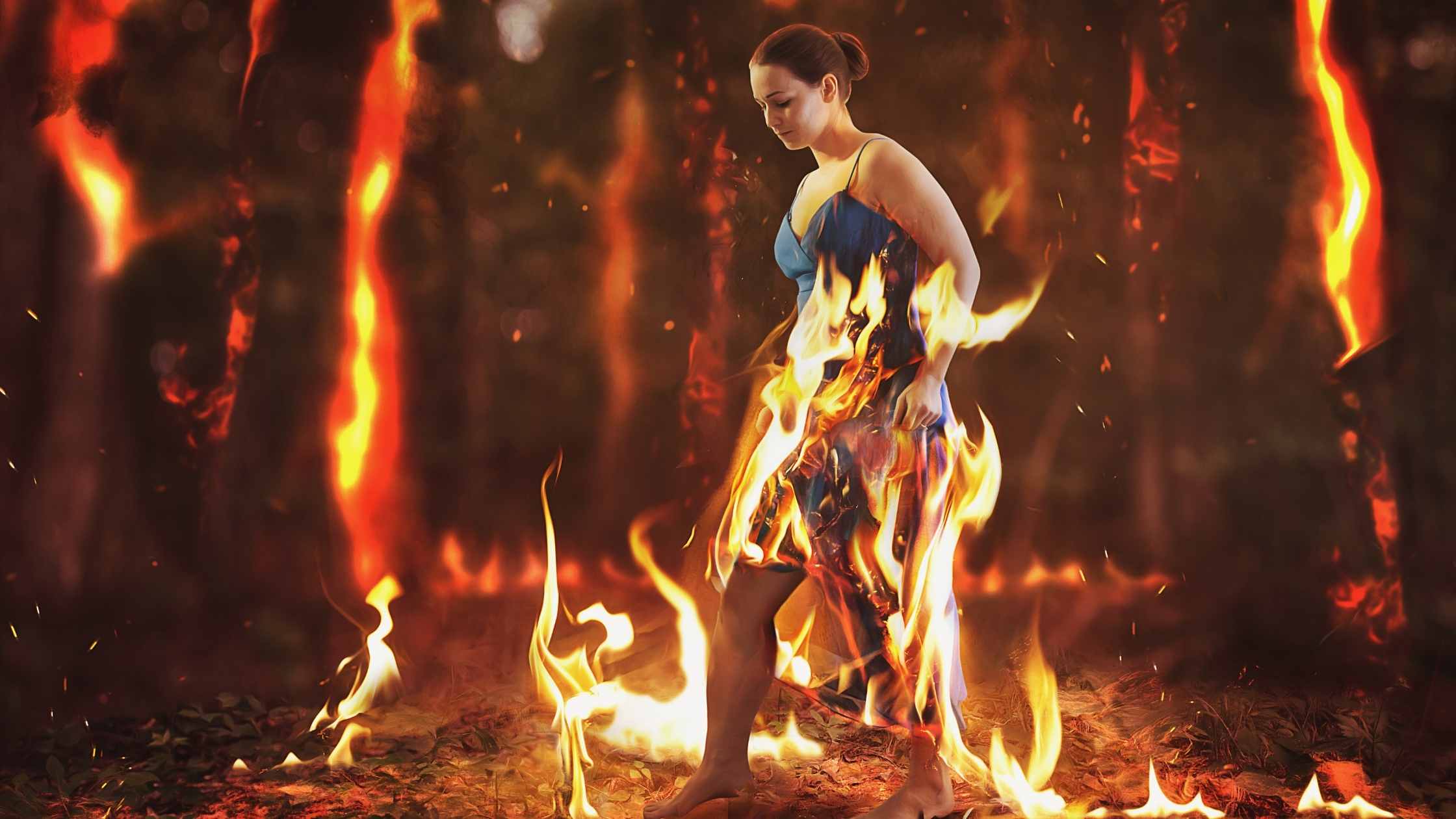 Woman walks through a burning forest fire